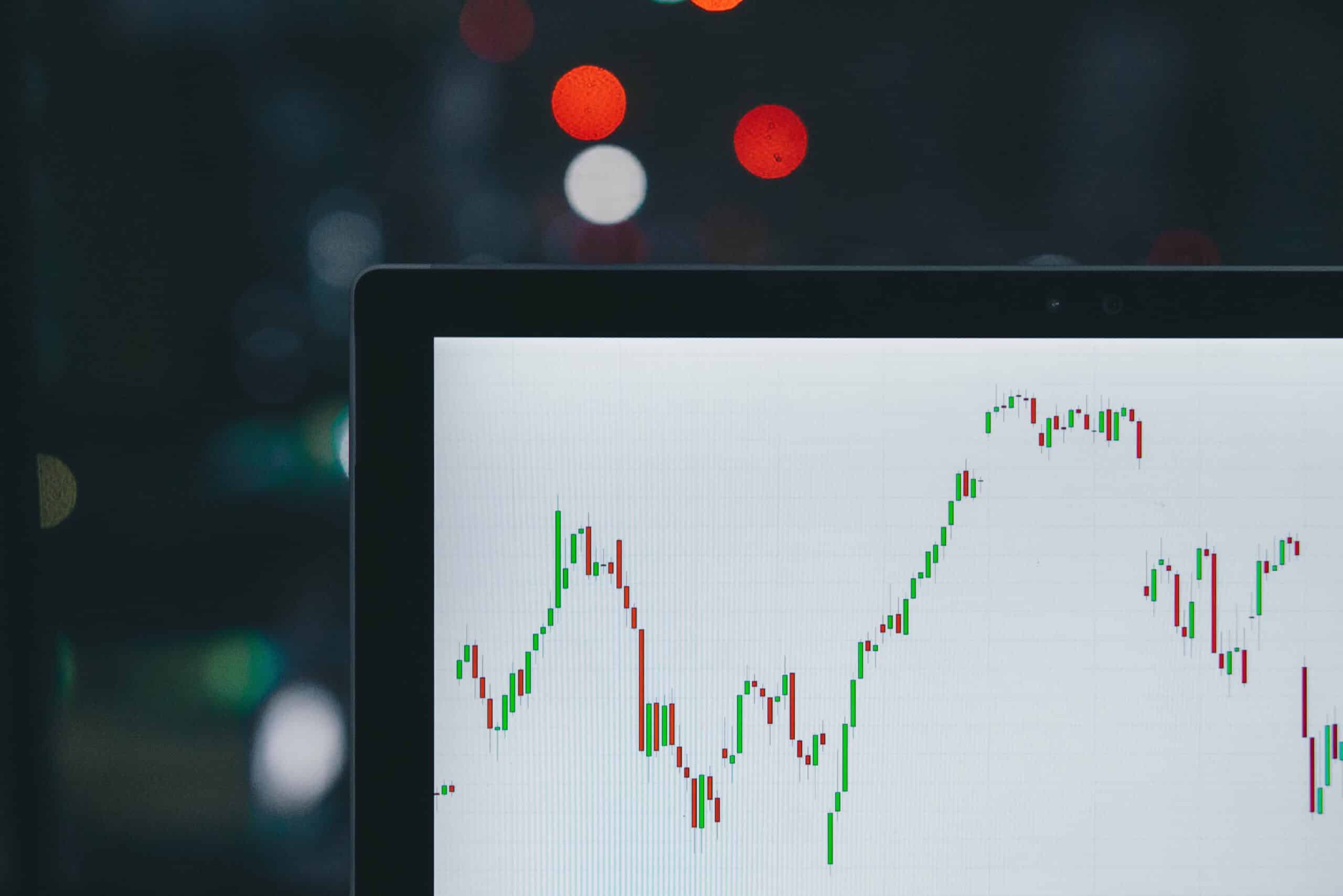 corner of laptop and trading chart