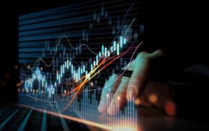 hand holding a pen working on virtual trading chart